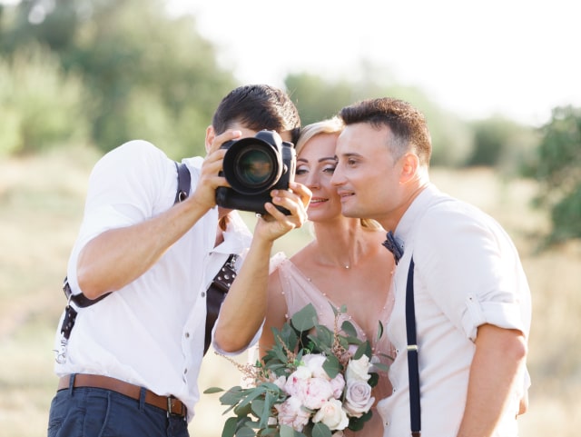 Hochzeitsfotograf zeigt dem Brautpaar Fotos